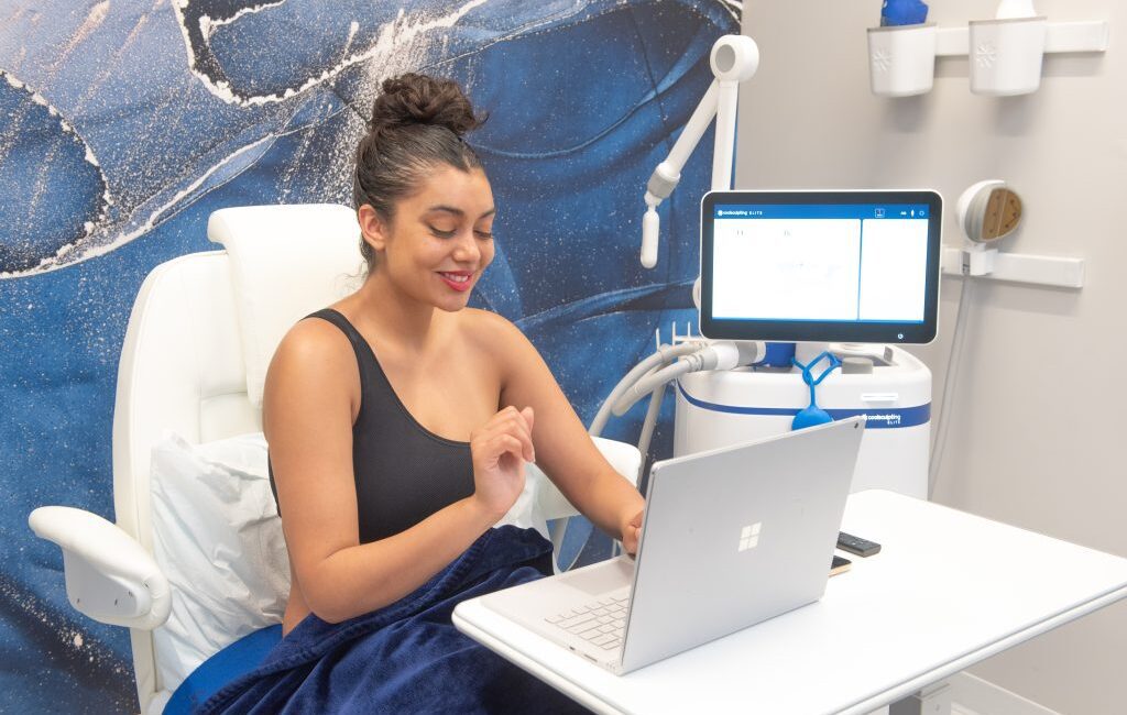 woman chilling while undergoing coolsculpting treatment