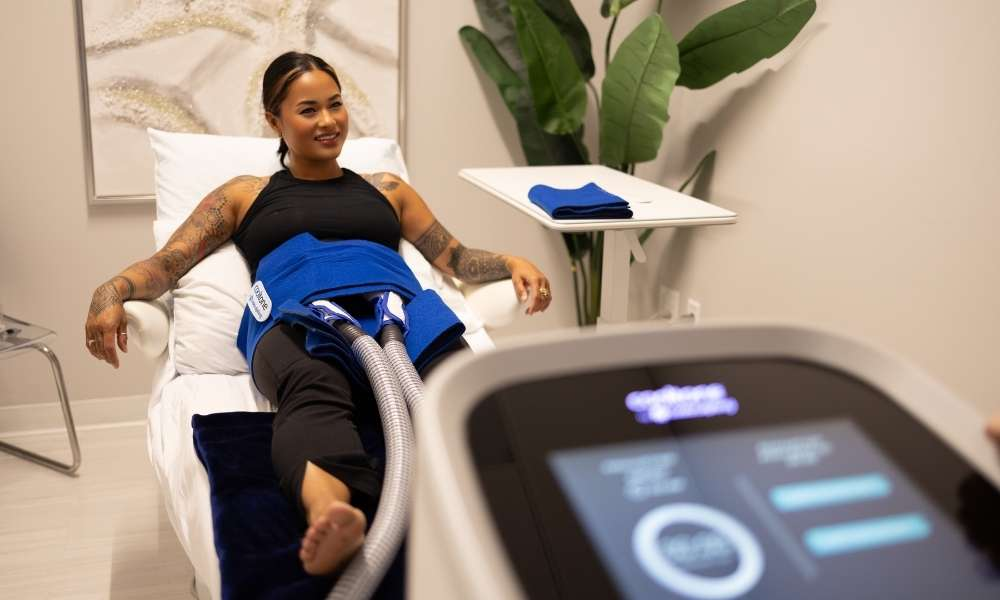 Woman receiving CoolTone muscle toning treatment for abdominal definition at Sculptology Lafayette.