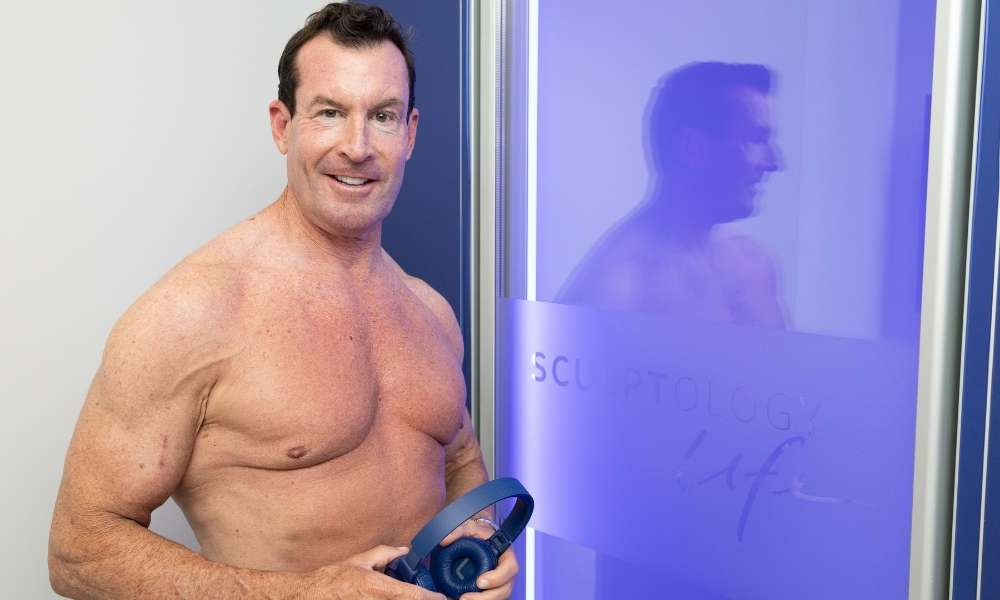 Male client entering the Whole Body Cryotherapy chamber for recovery at Sculptology Lafayette.