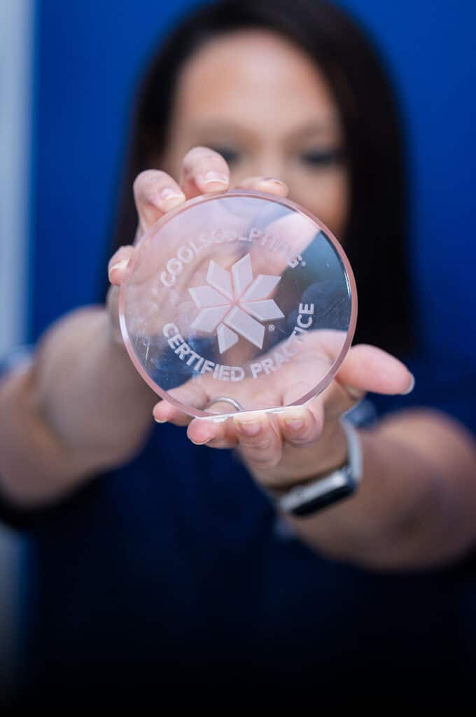 Woman holding CoolSculpting award for Sculptology Wellness Center in California
