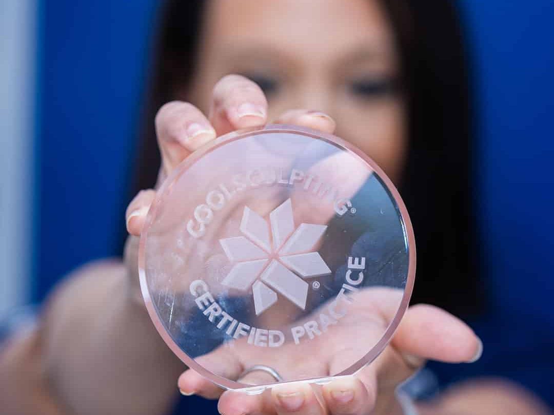 Woman holding CoolSculpting award for Sculptology Wellness Center in California